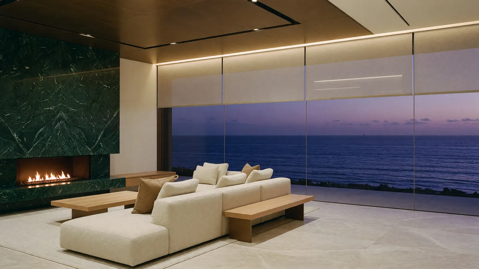 A modern living room with a green marble fireplace wall and a glass wall to the ocean